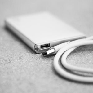 Monochromatic close-up of an external hard drive with a USB cable.