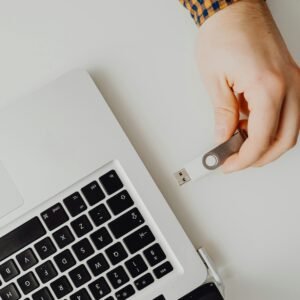 Hand inserting USB drive into laptop. Modern tech connection concept.